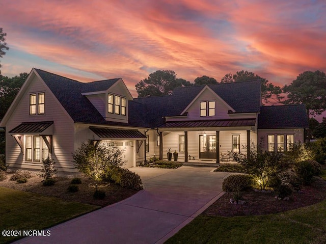 modern inspired farmhouse featuring covered porch and a lawn