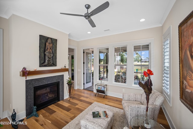 living room featuring ceiling fan, crown molding, and light hardwood / wood-style floors