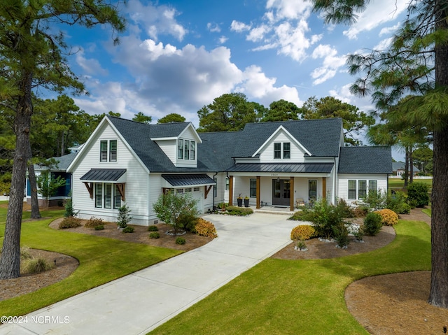 view of front of home with a front yard, a garage, and a porch