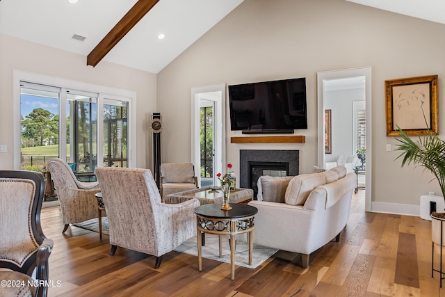 living room featuring beam ceiling, hardwood / wood-style floors, and high vaulted ceiling