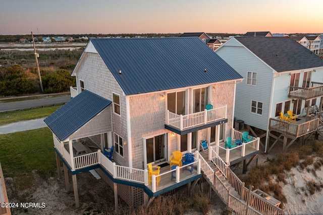 back house at dusk with a balcony