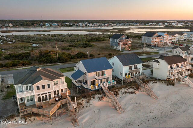 aerial view at dusk featuring a water view