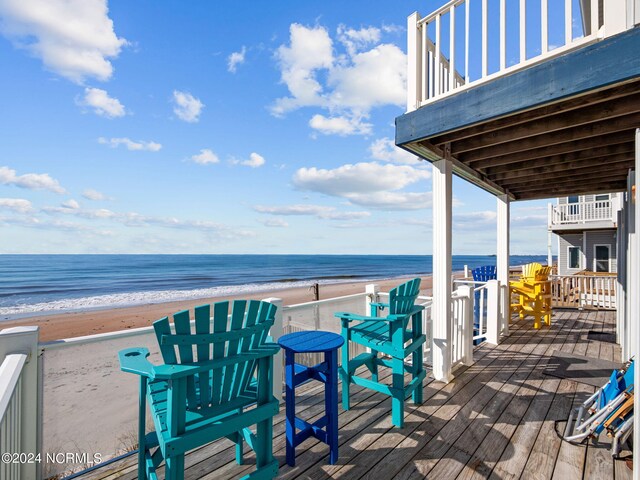 wooden deck with a beach view and a water view