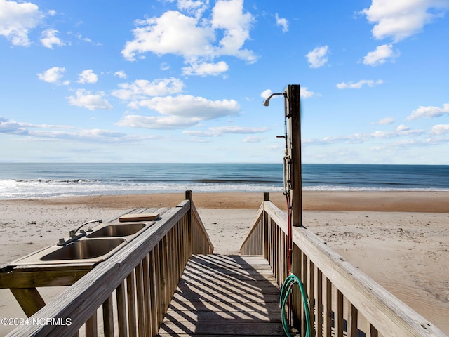 view of property's community with sink, a beach view, and a water view