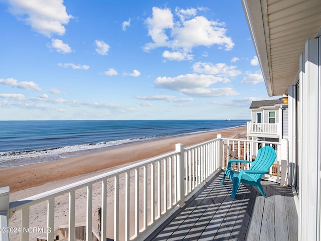 balcony featuring a water view and a view of the beach