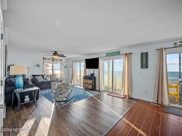 living room featuring a wealth of natural light, ceiling fan, a textured ceiling, and wood-type flooring