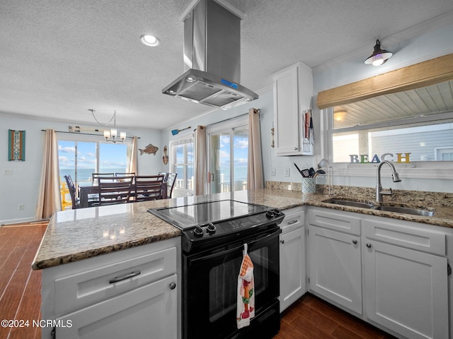 kitchen featuring sink, kitchen peninsula, black electric range oven, island exhaust hood, and white cabinets