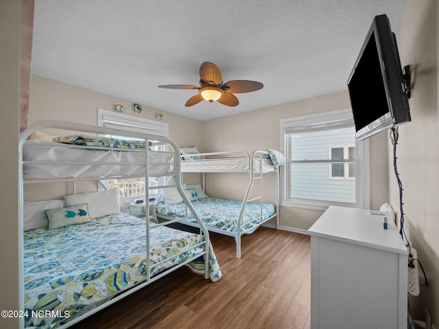 bedroom featuring a textured ceiling, ceiling fan, and wood-type flooring