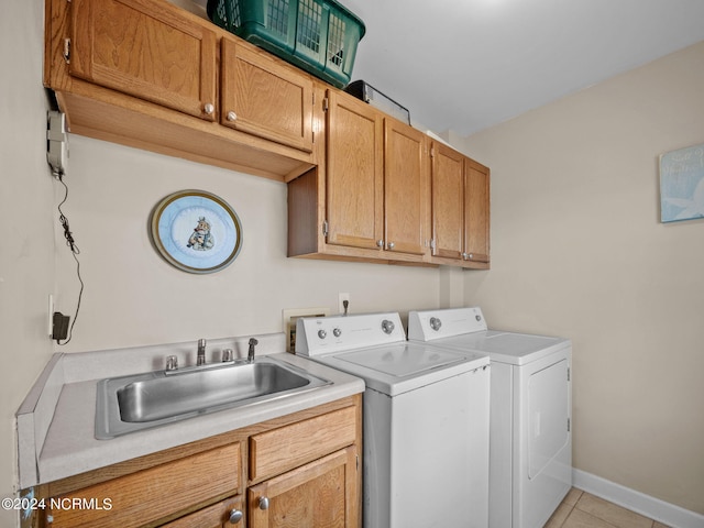 clothes washing area with separate washer and dryer, sink, light tile patterned floors, and cabinets