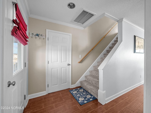 interior space with ornamental molding and a textured ceiling