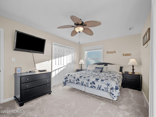 bedroom featuring ceiling fan, light carpet, and a closet