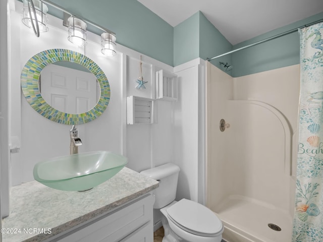 bathroom featuring curtained shower, vanity, and toilet