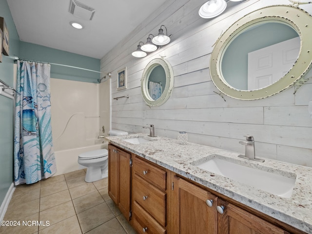 full bathroom with wood walls, vanity, shower / bath combo with shower curtain, tile patterned flooring, and toilet