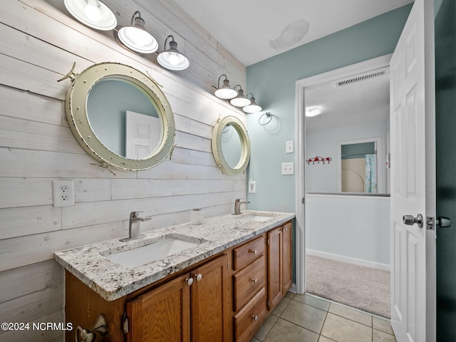 bathroom featuring tile patterned floors, wood walls, and vanity