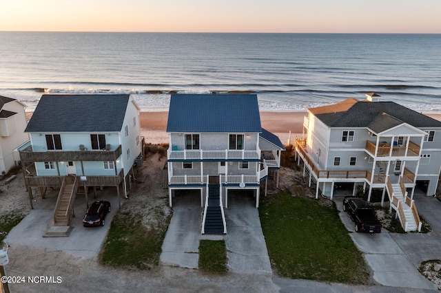 aerial view at dusk featuring a water view