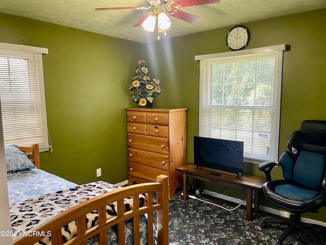 carpeted bedroom with a textured ceiling and ceiling fan