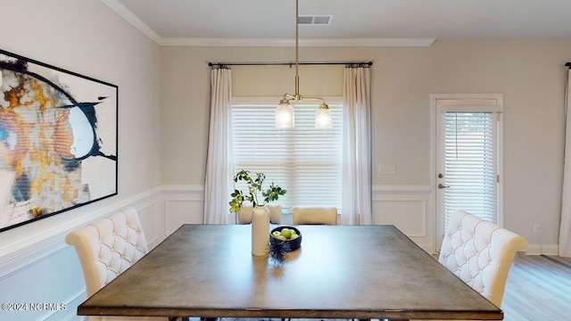 dining space with ornamental molding and hardwood / wood-style floors