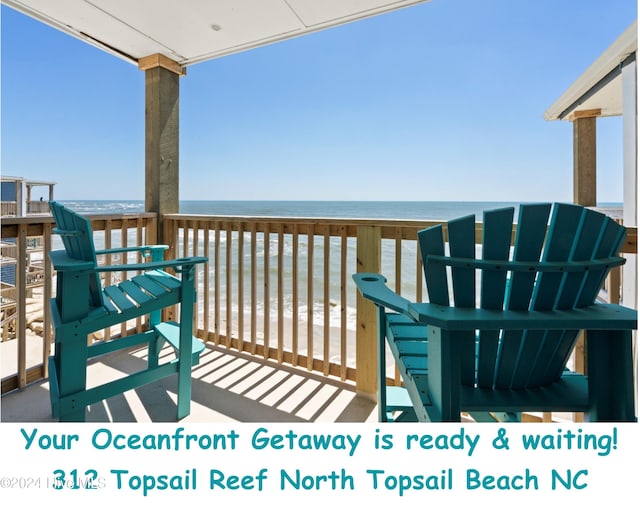 wooden deck with a beach view and a water view