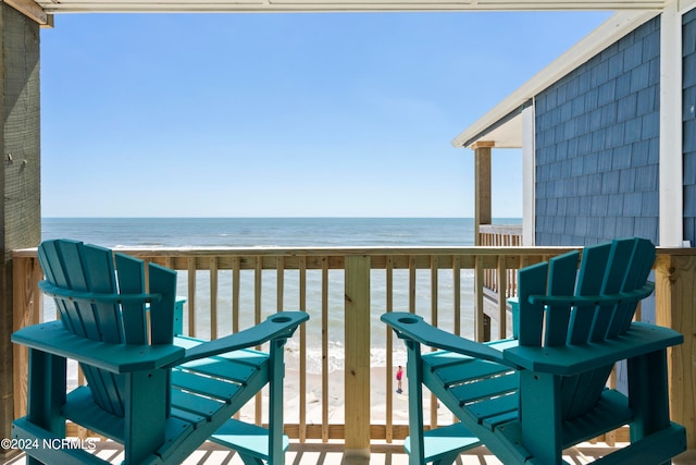 balcony featuring a water view and a beach view