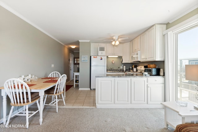 kitchen with white cabinetry, white appliances, a healthy amount of sunlight, and crown molding