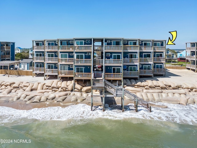 view of building exterior featuring a water view and a view of the beach