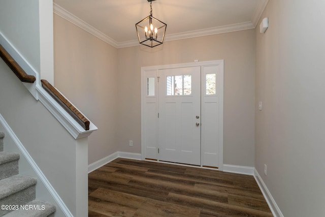 foyer entrance with dark hardwood / wood-style flooring, crown molding, and an inviting chandelier