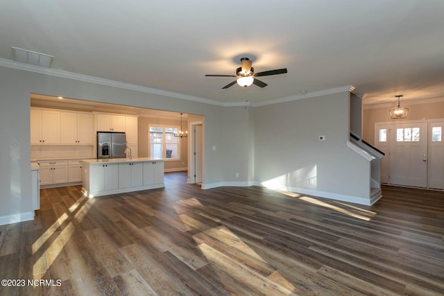 unfurnished living room featuring ornamental molding, dark hardwood / wood-style flooring, plenty of natural light, and ceiling fan with notable chandelier