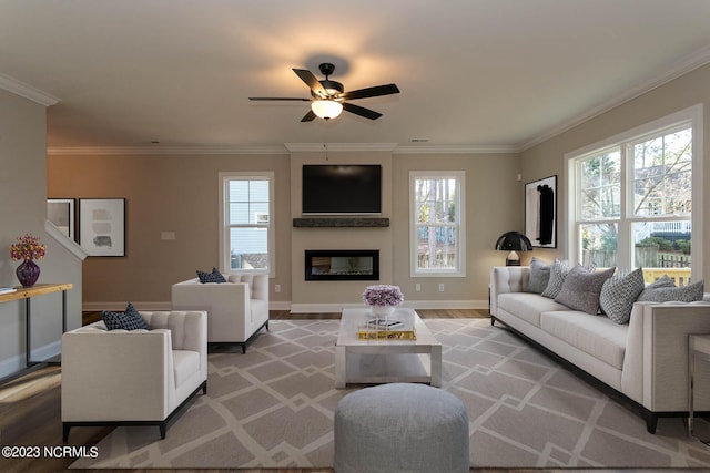 living room featuring ceiling fan, crown molding, hardwood / wood-style flooring, and a wealth of natural light