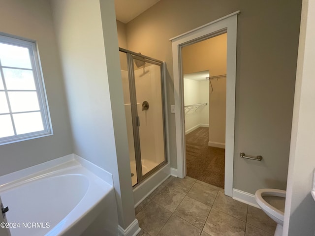 bathroom featuring plus walk in shower, toilet, and tile patterned flooring