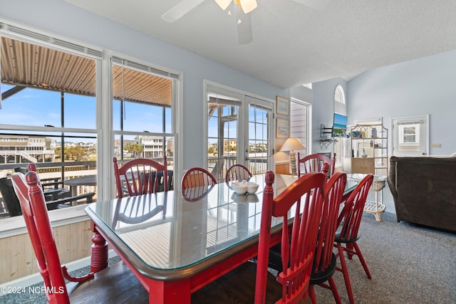 dining space featuring ceiling fan, carpet flooring, and a textured ceiling