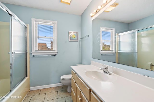 full bathroom with large vanity, tile floors, toilet, and enclosed tub / shower combo