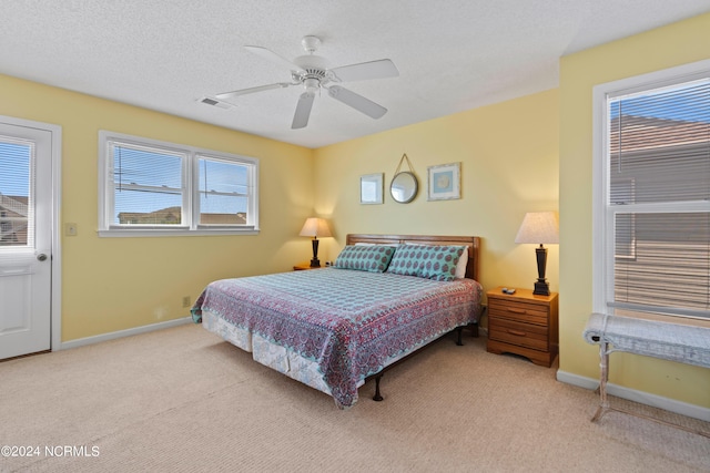 bedroom with carpet, ceiling fan, a textured ceiling, and multiple windows