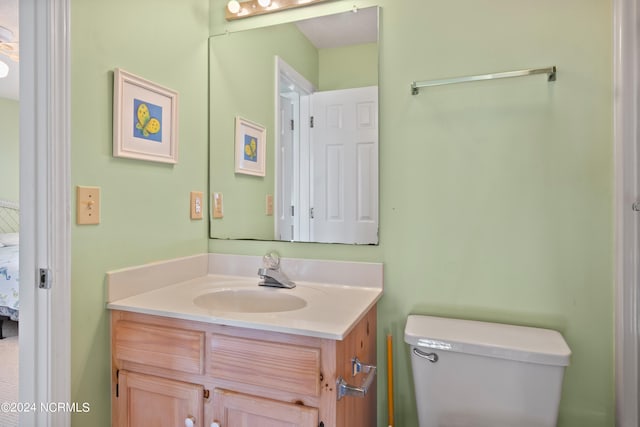 bathroom featuring vanity with extensive cabinet space and toilet