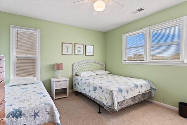 bedroom featuring ceiling fan, carpet flooring, and a textured ceiling