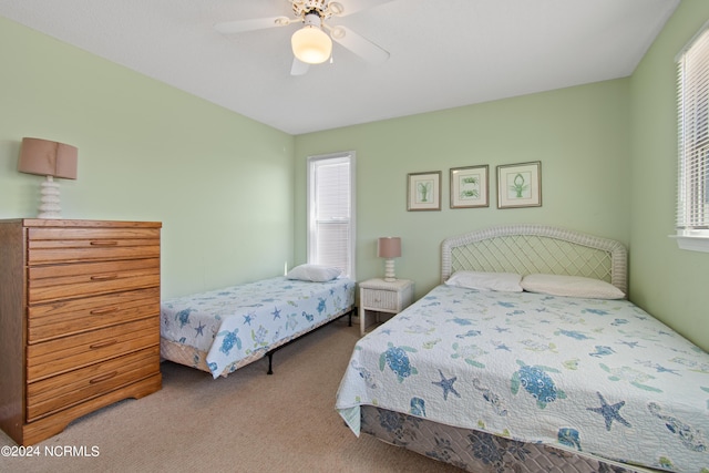 carpeted bedroom with multiple windows and ceiling fan