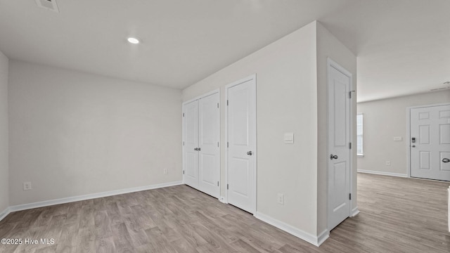 unfurnished bedroom featuring recessed lighting, visible vents, baseboards, and wood finished floors