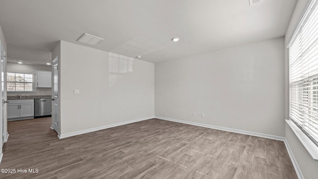 unfurnished room featuring a sink, baseboards, and wood finished floors