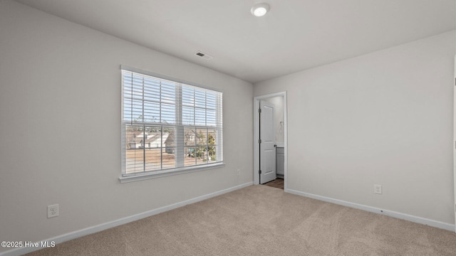 carpeted spare room with visible vents and baseboards