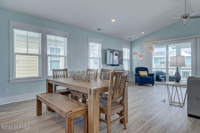 dining area featuring vaulted ceiling, light hardwood / wood-style flooring, and a healthy amount of sunlight