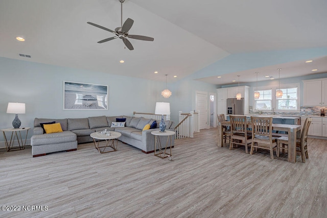 living room featuring light wood-type flooring, ceiling fan, and lofted ceiling