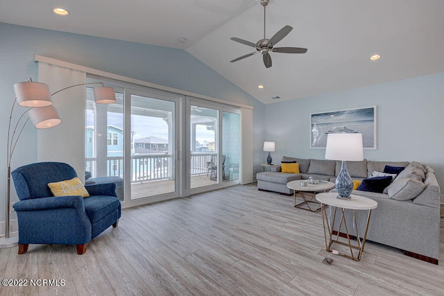 living room featuring ceiling fan, vaulted ceiling, and light wood-type flooring