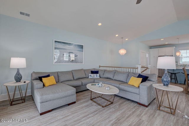 living room featuring light hardwood / wood-style floors and vaulted ceiling