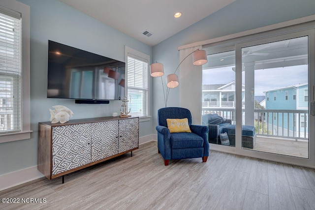 sitting room with lofted ceiling and light wood-type flooring