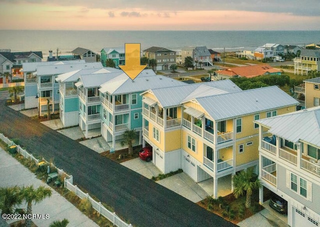 aerial view at dusk featuring a water view