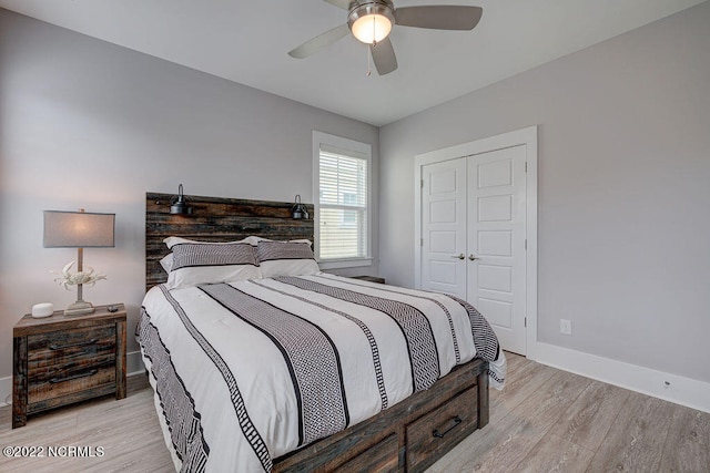 bedroom with light hardwood / wood-style flooring, ceiling fan, and a closet