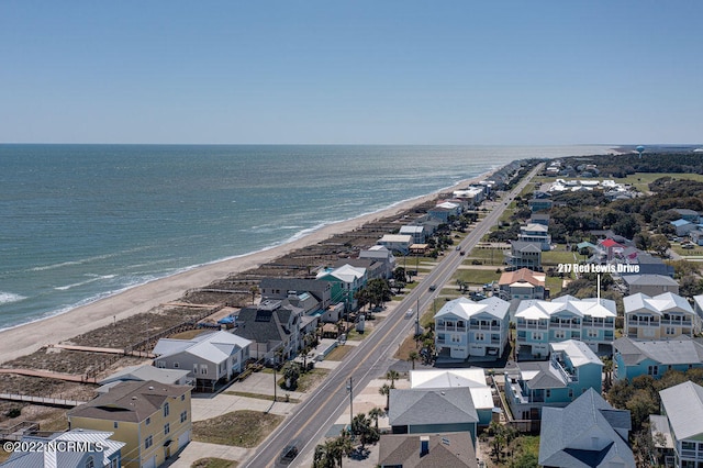 birds eye view of property featuring a water view and a beach view