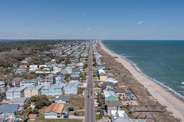 birds eye view of property with a water view and a beach view