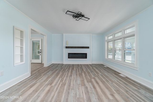 unfurnished living room with built in features and light hardwood / wood-style floors