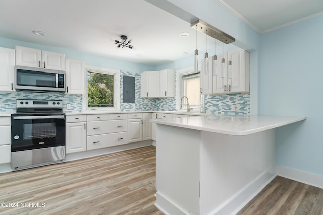 kitchen with kitchen peninsula, appliances with stainless steel finishes, white cabinetry, pendant lighting, and light wood-type flooring