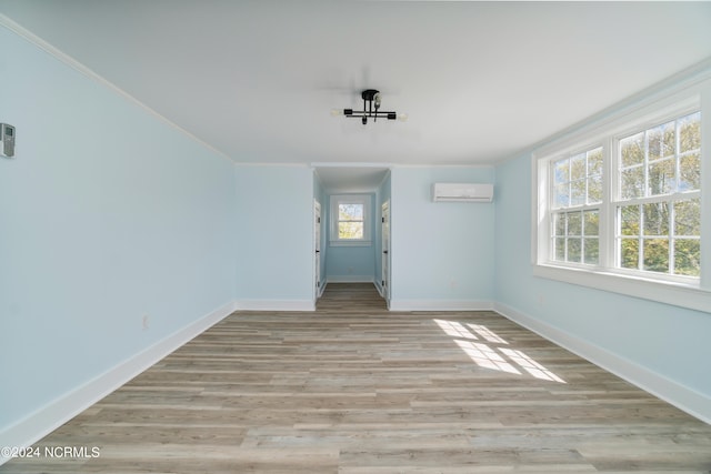 unfurnished room featuring light hardwood / wood-style floors and a wall unit AC